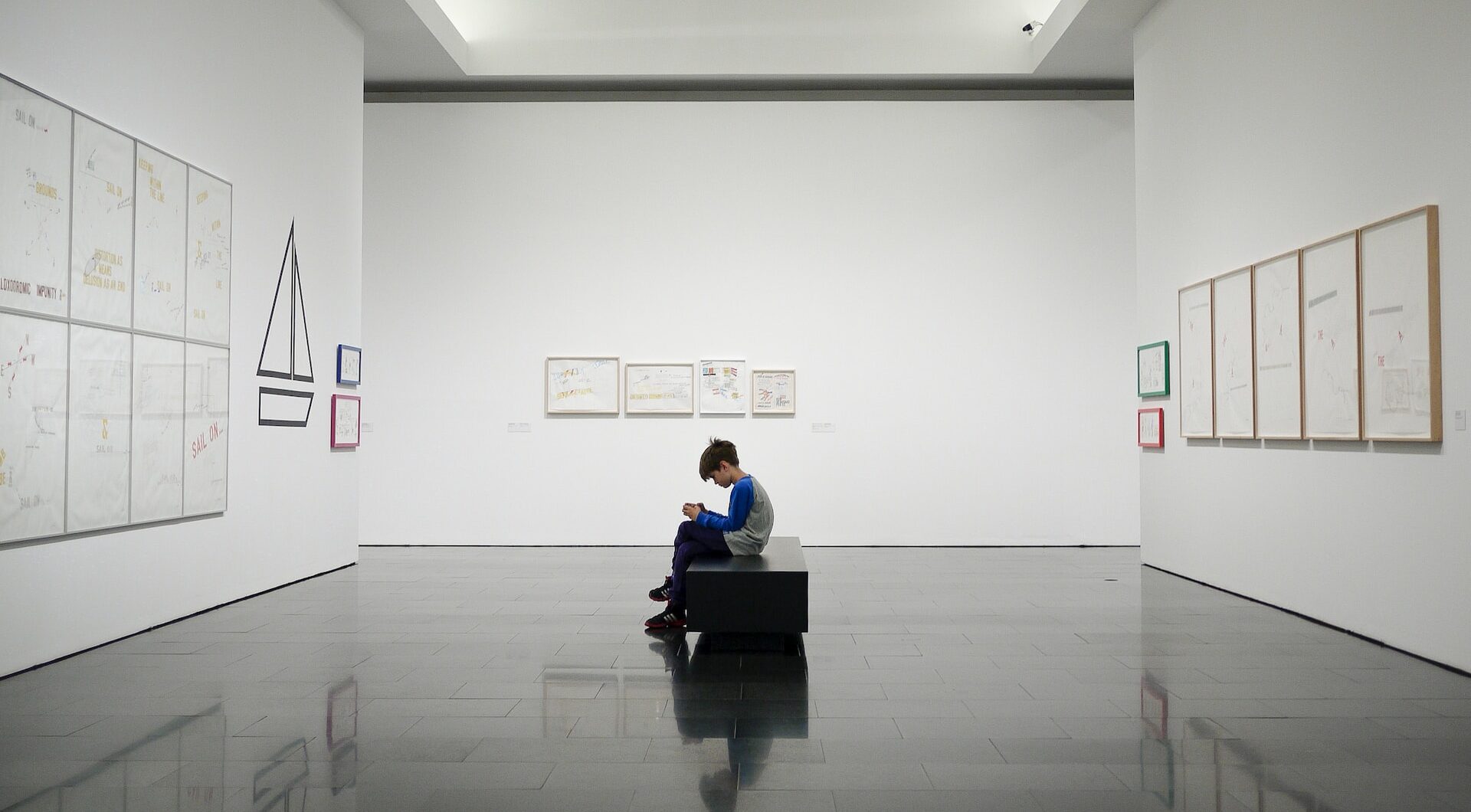 Gamification im Museum: Junge sitzt alleine in einer Kunstausstellung